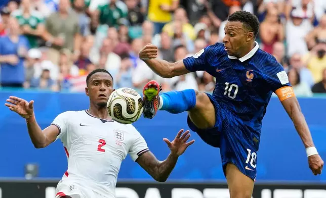 France's Kylian Mbappe (10) takes a shot as England's Ezri Konsa (2) defends during the World Cup third-place playoff soccer match between France and England in Miami Gardens, Fla., Saturday, July 18, 2026. (AP Photo/Rebecca Blackwell)