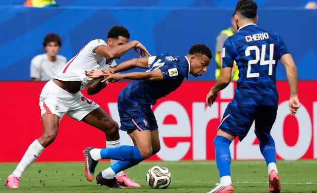 France's Kylian Mbappe, center, battles for the ball with England's Jarell Quansah (26), left, as Rayan Cherki (24) look on during the World Cup third-place playoff soccer match between France and England in Miami Gardens, Fla., Saturday, July 18, 2026. (AP Photo/Rebecca Blackwell)