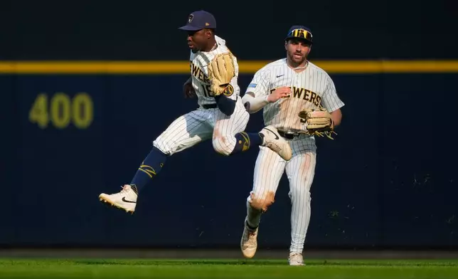 Milwaukee Brewers center fielder Luis Lara (18) makes a running catch in front of center fielder Garrett Mitchell (5) on a fly ball hit by Miami Marlins' Javier Sanoja during the eighth inning of a baseball game Saturday, July 18, 2026, in Milwaukee. (AP Photo/Kayla Wolf)