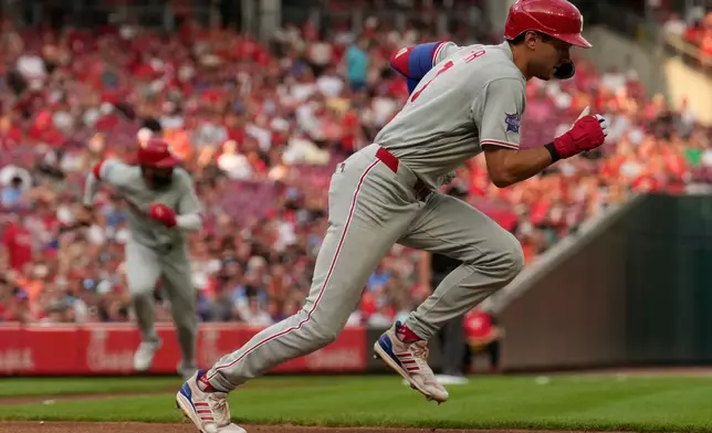 Philadelphia Phillies' Trea Turner grounds out as he runs to first base as Derek Hill scores, at left, and during the third inning of a baseball game against the Cincinnati Reds in Cincinnati, Tuesday, July 7, 2026. (AP Photo/Carolyn Kaster)