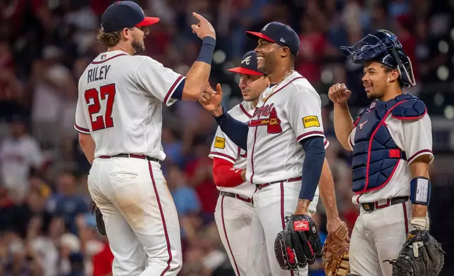 Atlanta Braves Raisel Iglesias (26), right, is congradulated by teammate Austin Riley (27), left, at the end of a baseball game against the St. Louis Cardinals Wednesday, July 1, 2026, in Atlanta. (AP Photo/Erik Rank)