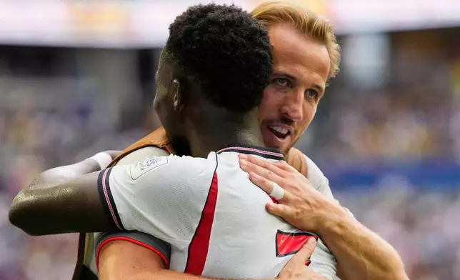 England's Harry Kane, right, embraces Bukayo Saka after Saka their fifth goal, his third, during the World Cup third-place playoff soccer match between France and England in Miami Gardens, Fla., Saturday, July 18, 2026. (AP Photo/Lynne Sladky)