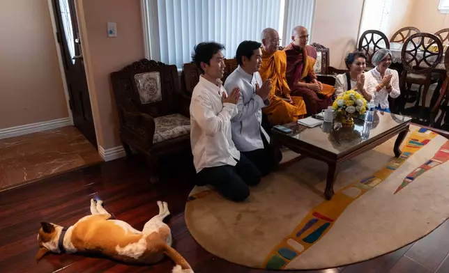 Bhikkhu Pannakara, third from right, a Buddhist monk who led a Walk for Peace from Fort Worth, Texas, to Washington, D.C., poses for a group photo as his dog, Aloka, rests nearby in the North Hollywood section of Los Angeles, Monday, July 13, 2026. (AP Photo/Jae C. Hong)