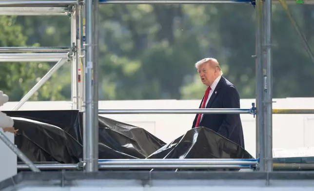 President Donald Trump walks through scaffolding on the North Portico as he leaves the White House to travel to Medora, N.D. for the opening of the Theodore Roosevelt Presidential Library, Wednesday, July 1, 2026, in Washington. (AP Photo/Manuel Balce Ceneta)