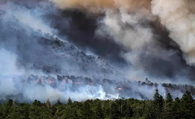 A helicopter provides bucket drops to assist firefighters battling the Gold Mountain Fire on the town line of Ouray and Ridgeway, Colo., Sunday, June 28, 2026. (Michael G. Seamans/The Gazette via AP)