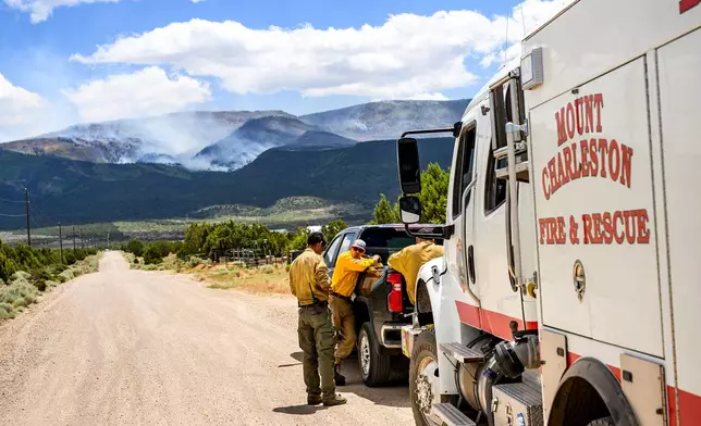 Firefighters gather as the Cottonwood Fire burns near Beaver, Utah, on Saturday, June 27, 2026. (AP Photo/Noah Berger)