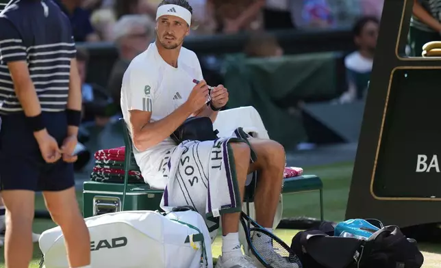 Alexander Zverev of Germany prepares to inject himself with insulin during a changeover in the men's singles final match against Jannik Sinner of Italy, at Wimbledon Tennis Championships in London, Sunday, July 12, 2026. (AP Photo/Kirsty Wigglesworth)