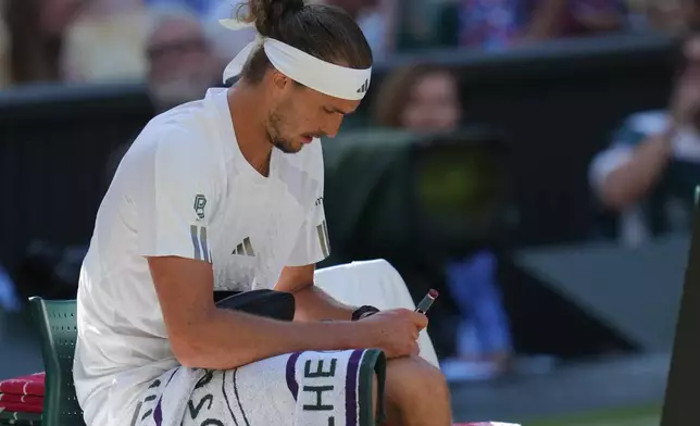 Alexander Zverev of Germany injects himself with insulin during a changeover in the men's singles final match against Jannik Sinner of Italy, at Wimbledon Tennis Championships in London, Sunday, July 12, 2026. (AP Photo/Kirsty Wigglesworth)