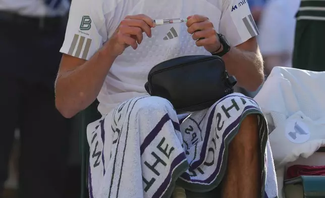 Alexander Zverev of Germany prepares to inject himself with insulin during a changeover in the men's singles final match against Jannik Sinner of Italy, at Wimbledon Tennis Championships in London, Sunday, July 12, 2026. (AP Photo/Kin Cheung)