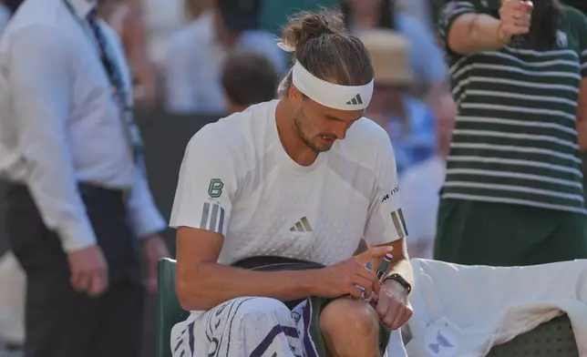 Alexander Zverev of Germany injects himself with insulin during a changeover in the men's singles final match against Jannik Sinner of Italy, at Wimbledon Tennis Championships in London, Sunday, July 12, 2026. (AP Photo/Kin Cheung)