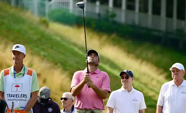 Scottie Scheffler looks up at his driver before teeing off the first playoff hole of the Travelers Championship golf tournament at TPC River Highlands, Monday, June 29, 2026, in Cromwell, Conn. (AP Photo/Jessica Hill)