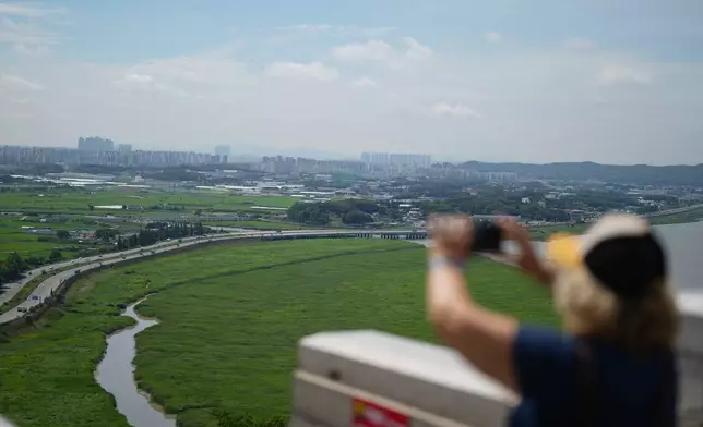 Military barbed-wire fences are placed along the express road Jayuro, with a view of the landscape of Paju visible beyond them in Paju, South Korea, Tuesday, July 7, 2026. (AP Photo/Lee Jin-man)