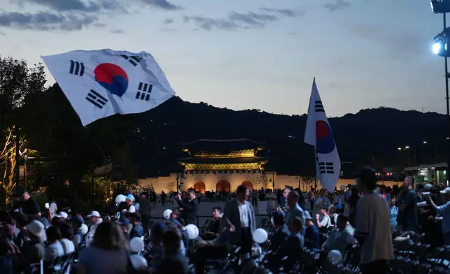 People hold national flags after a ceremony to mark the 76th anniversary of the outbreak of the Korean War in Seoul, South Korea, Tuesday, June 23, 2026. (AP Photo/Lee Jin-man)