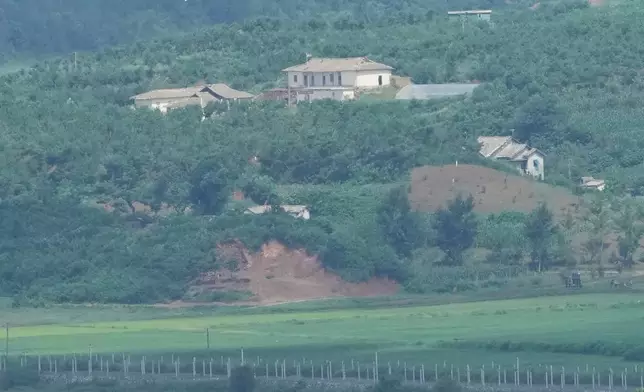 A North Korean flag, center top, flutters in the wind on North Korea's town, Kaepoong, as seen from the unification observatory in Paju, South Korea, Tuesday, July 7, 2026. (AP Photo/Lee Jin-man)