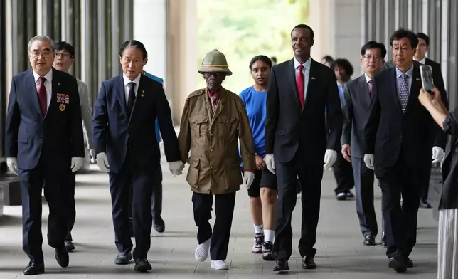 Ethiopian veteran of the Korean War, Tesfaye Asmamaw, 95, walks with South Korean minister of Patriots and Veterans Affairs, Kwon Oh-eul, second from left, in Seoul, South Korea, Tuesday, June 30, 2026. (AP Photo/Lee Jin-man)