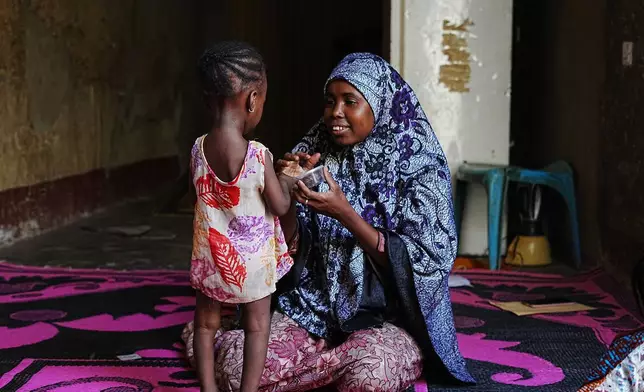 Maryam Aminu plays with her daughter Farisa, who has relapsed into malnutrition, at their house in Kware Sokoto, northwestern Nigeria, Wednesday, July 15, 2026. (AP Photo/Sunday Alamba)