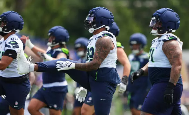 Seattle Seahawks defensive end Leonard Williams, center, warms up during the NFL football team's training camp, Saturday, July 25, 2026, in Renton, Wash. (AP Photo/Lindsey Wasson)