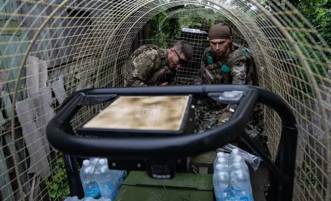 In this photo provided by Ukraine's 93rd Kholodnyi Yar Separate Mechanized Brigade press service, a Ukrainian serviceman unloads a ground drone that carries ammunition, water, and provisions in the frontline town of Druzhkivka, Donetsk region, Ukraine Friday, July 10, 2026. (Iryna Rybakova/Ukraine's 93rd Mechanized Brigade via AP)