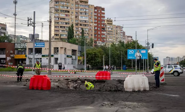 A sapper examines the impact site of a Russian missile in a residential area of Kyiv, Saturday, July 11, 2026. (AP Photo/Dan Bashakov)