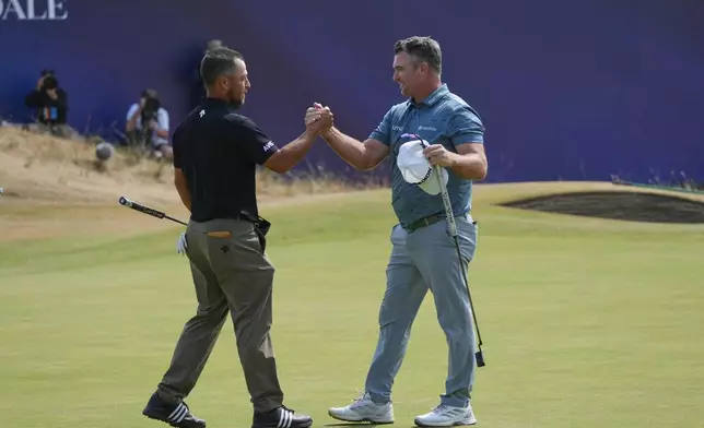 Xander Schauffele of the United States, left, and Ryan Fox of New Zealand shake hands after complete their third rounds on the 18th green during the third day of the British Open Golf championships at Royal Birkdale golf club, in Southport, England, Saturday, July 18, 2026. (AP Photo/Jon Super)