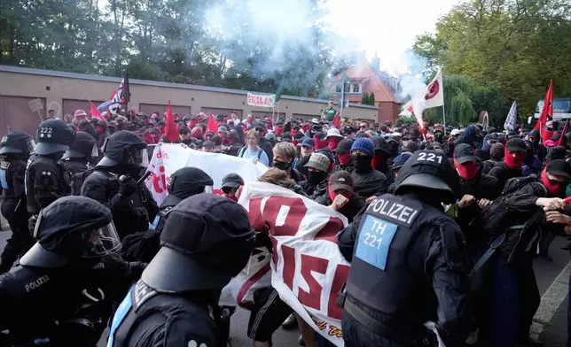 Protesters scuffle with police officers before a party convention of Alternative for Germany, or AfD in Erfurt, Germany, Saturday, July 4, 2026. (AP Photo/Ebrahim Noroozi)