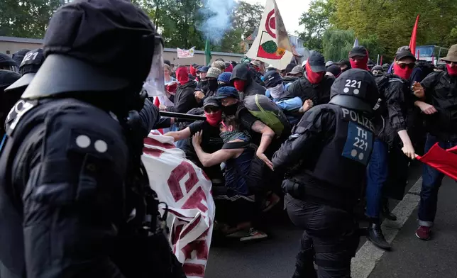 Protesters scuffle with police officers before a party convention of Alternative for Germany, or AfD in Erfurt, Germany, Saturday, July 4, 2026. (AP Photo/Ebrahim Noroozi)