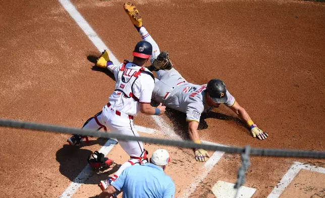 Pittsburgh Pirates' Konnor Griffin, right, steals home to score against Washington Nationals catcher Drew Millas, left, during the first inning of a baseball game, Saturday, July 4, 2026, in Washington. (AP Photo/Nick Wass)