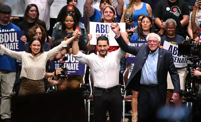 From left foreground, U.S. Rep. Alexandria Ocasio-Cortez, D-N.Y., Michigan Democratic U.S. Senate primary candidate Abdul El-Sayed, and U.S. Sen. Bernie Sanders, I-VT. join hands together following a campaign rally, Saturday, July 18, 2026, in Detroit. (AP Photo/Jose Juarez)