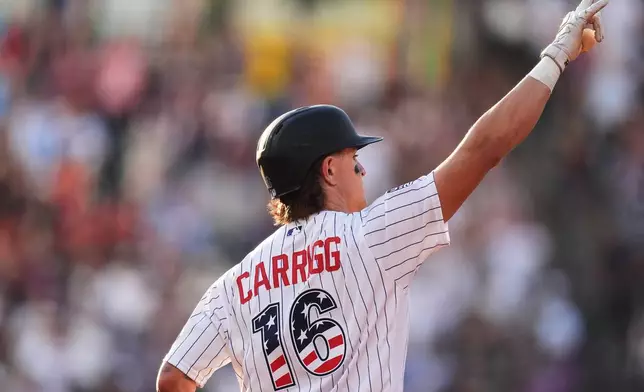 Colorado Rockies' Cole Carrigg gestures to the bullpen as he circles the bases after hititng a three-run home run off San Francisco Giants starting pitcher Robbie Ray in the first inning of a baseball game Saturday, July 4, 2026, in Denver. (AP Photo/David Zalubowski)