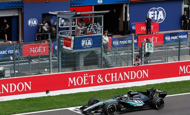 The checkered flag is waved as Mercedes driver Andrea Kimi Antonelli of Italy crosses the finish line to win the Formula One Grand Prix at the Spa-Francorchamps racetrack in Spa, Belgium, Sunday, July 19, 2026. (AP Photo/Geert Vanden Wijngaert)