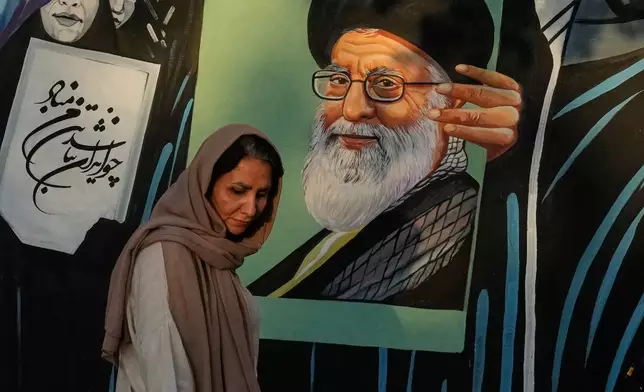 A woman walks past a mural depicting a portrait of the late Iranian Supreme Leader Ayatollah Ali Khamenei, who was killed in the U.S. and Israel strike on Feb. 28, in downtown Tehran, Iran, Saturday, July 18, 2026. (AP Photo/Vahid Salemi)