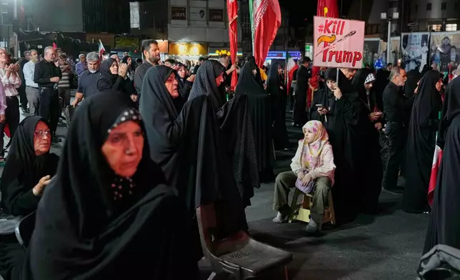 Women gather during a pro-government rally as one holds a sign reading in English, "Kill Trump," in Tehran, Friday, July 17, 2026. (AP Photo/Vahid Salemi)