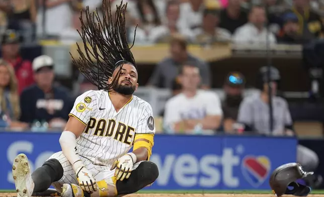 San Diego Padres' Fernando Tatis Jr. falls after moving away from an inside pitch while batting during the eighth inning of a baseball game against the Colorado Rockies Tuesday, July 28, 2026, in San Diego. (AP Photo/Gregory Bull)