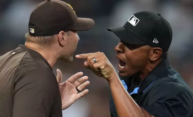 San Diego Padres manager Craig Stammen, left, argues with home plate umpire Jeremie Rehak. during the fourth inning of a baseball game against the Colorado Rockies Tuesday, July 28, 2026, in San Diego. (AP Photo/Gregory Bull)