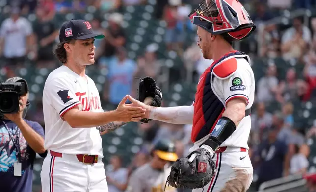 Minnesota Twins relief pitcher Travis Adams, left, celebrates with catcher Ryan Jeffers, right, after a baseball game against the Athletics, Sunday, July 26, 2026, in Minneapolis. (AP Photo/Bruce Kluckhohn)