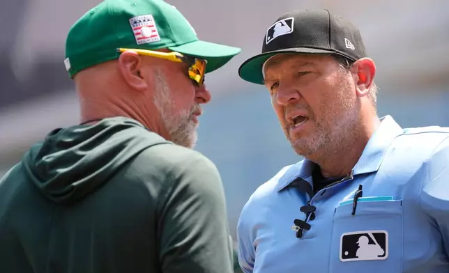 Home plate umpire Chad Fairchild, right, explains to Athletics manager Mark Kotsay why he threw out coach Chris Cron after an argument over a balk call in the second inning of a baseball game against the Minnesota Twins, Sunday, July 26, 2026, in Minneapolis. (AP Photo/Bruce Kluckhohn)