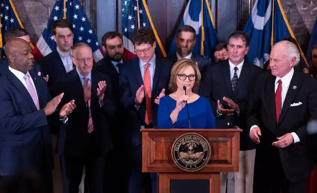 Newly appointed U.S. interim Senator, Darline Graham Nordone, with South Carolina Gov. Henry McMaster, right, and Sen. Tim Scott (R-SC), left, speaks to members of the press after being appointed to fill the vacancy created by the passing of her brother, U.S. Senator Lindsey Graham, at the statehouse Monday, July 13, 2026, in Columbia, S.C. (AP Photo/Sean Rayford) CORRECTION: Corrects senator Scott's first name.
