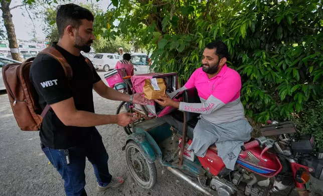 Hamza Ali, 28, who lost both legs in a road accident, delivers a meal order in Islamabad, Pakistan, Friday, July 17, 2026. (AP Photo/Anjum Naveed)