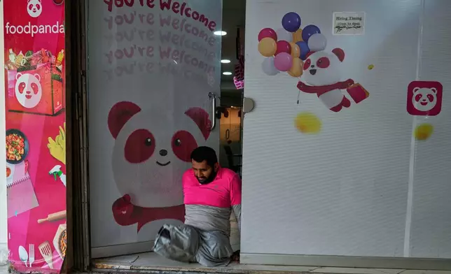 Hamza Ali, 28, who lost both legs in a road accident, leaves an office of foodpanda, a delivery platform, in Islamabad, Pakistan, Friday, July 17, 2026. (AP Photo/Anjum Naveed)