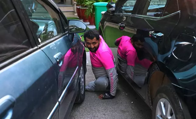 Hamza Ali, 28, who lost both legs in a road accident, navigates through parked cars after collecting a meal order from a food outlet for delivery in Islamabad, Pakistan, Friday, July 17, 2026. (AP Photo/Anjum Naveed)
