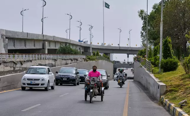 Hamza Ali, 28, who lost both legs in a road accident, rides to deliver a meal order to a customer in Islamabad, Pakistan, Friday, July 17, 2026. (AP Photo/Anjum Naveed)