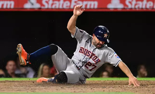 Houston Astros Jose Altuve (27) scores a run against the Los Angeles Angels during the seventh inning of a baseball game Wednesday, July 29, 2026, in Anaheim, Calif. (AP Photo/Wally Skalij)