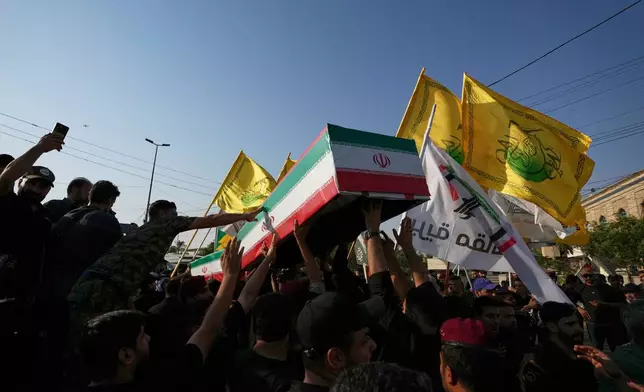 Mourners carry the coffin of an Iranian adviser draped in the Iranian flag during a group funeral for Iranian advisers and Popular Mobilization Forces fighters killed in airstrikes on bases belonging to Iraq's Popular Mobilization Forces, a coalition of predominantly Shiite militias that includes Iran-backed groups, in Mosul, Iraq, Wednesday, July 29, 2026. (AP Photo/Hadi Mizban)