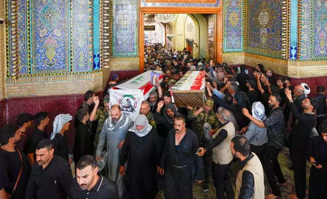 Mourners carry the coffins of Popular Mobilization Forces fighters during their funeral at the Imam Ali Shrine in Najaf, Iraq, Thursday, July 30, 2026, after they were killed in airstrikes on PMF bases. (AP Photo/Anmar Khalil)