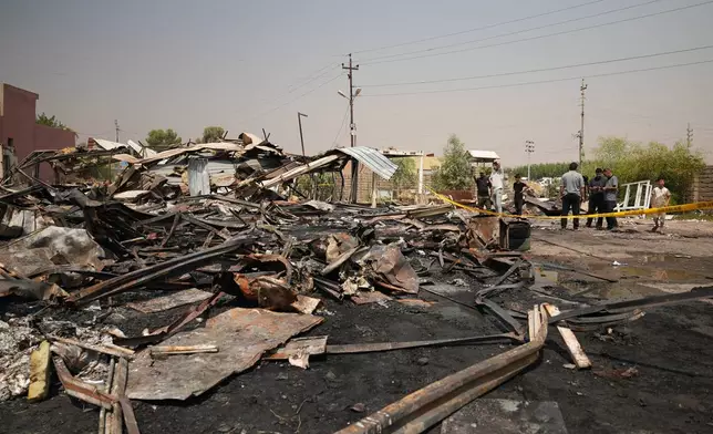 Iraqis inspect damaged structures at the site of an airstrike on a Popular Mobilization Forces base in Mosul, Iraq, Wednesday, July 29, 2026. (AP Photo/Farid Abdulwahed)