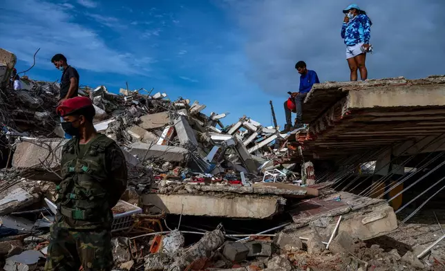Volunteers and rescuers help to find survivors in a collapsed building in Caraballeda, La Guaira state, Venezuela, on June 30, 2026, following the June 24 twin earthquakes. (Miguel Medina/Pool Photo via AP)