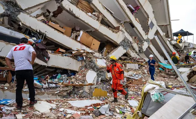 Volunteers and a Mexican rescuer help to find survivors in a collapsed building in Caraballeda, La Guaira state, Venezuela, on June 30, 2026, following the June 24 twin earthquakes. (Miguel Medina/Pool Photo via AP)