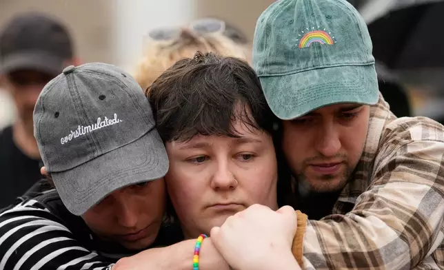 People gather outside the Brandenburg Gate for a demonstration in support of LGBTQ+ after a car rammed into a crowd at the Pride March in Berlin, Sunday, July 26, 2026. (AP Photo/Ebrahim Noroozi)