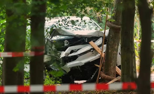 A vehicle crashed into a tree after an incident near Berlin's annual Pride event, in Berlin, Germany, Sunday, July 26, 2026. (AP Photo/Markus Schreiber)