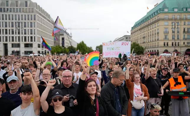 People gather outside the Brandenburg Gate for a demonstration in support of LGBTQ+ after a car rammed into a crowd at the Pride March in Berlin, Sunday, July 26, 2026. (AP Photo/Ebrahim Noroozi)